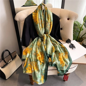 Detail of floral silk scarf with luxury peony patterns draped over an elegant chair