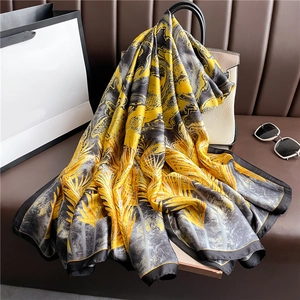 Dettaglio di un foulard in seta di lusso con foglie di palma su una borsa beige