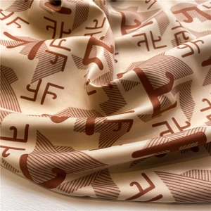 Gros plan sur un tissu satiné soyeux de luxe avec motif de lettres abstraites élégant