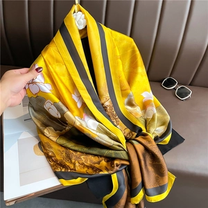 Detailed texture of luxurious silk scarf with lotus and lily pad prints on a leather sofa