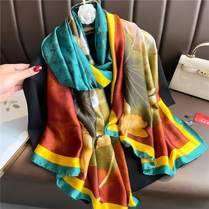 Detail of luxury silk scarf featuring lotus patterns and vibrant nature prints