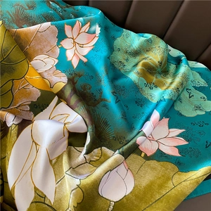 Macro detail of silk scarf showing lotus flowers and butterfly in Chinese art style