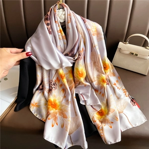 Detailed view of luxury large silk scarf with yellow floral and leopard print patterns