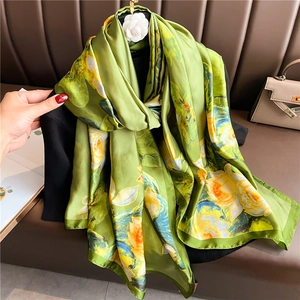 Detail of a large silk scarf with lotus print in green, yellow and white flowers