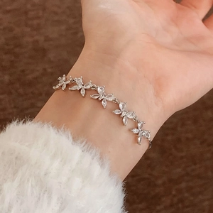 Elegantes silbernes Blumenarmband mit Zirkonia-Steinen am Handgelenk einer Frau