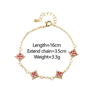 Detail of gold chain bracelet with rhombus red gemstone charms and white cubic zirconia