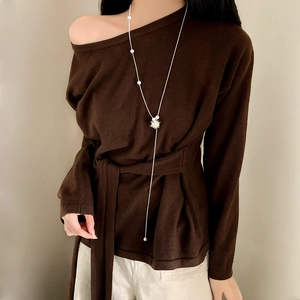 Elegante collana lunga di perle con ciondolo a stella mostrata su modella con maglieria