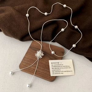 Collana lunga argentata con ciondolo a stella, perle bianche e nappe eleganti