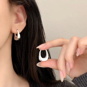 Minimalist silver U-shaped hoop earrings featuring a smooth polished metallic finish