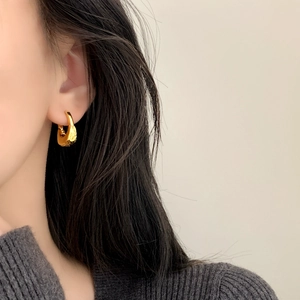 Elegant gold geometric earrings with hammered texture shown on model for a minimalist look