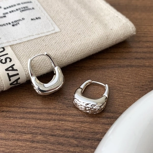 Macro detail of S925 sterling silver U-shaped hoop earrings with hammered texture finish