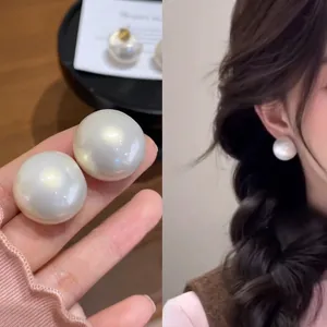 Lustrous white round pearl stud earrings with high mirror-like metallic shine and luxury finish