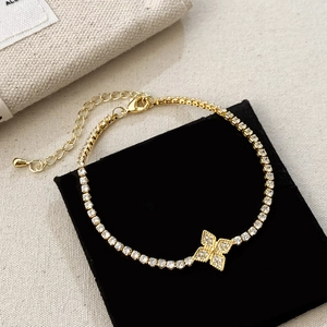 Detail eines Kleeblatt-Armbands in Gold mit Zirkonia auf schwarzem Samtkissen