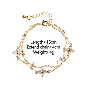 Close-up of double-layer gold chain bracelet with four-leaf zircon flower charms