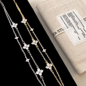 Double-layer gold and silver flower bracelets with pave zircon on a display stand