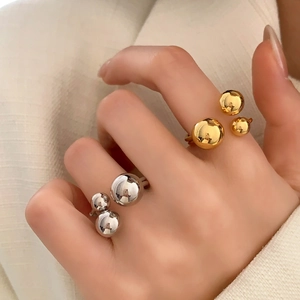 Minimalist three-ball open ring set in gold and silver finish on hand