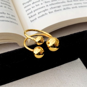 Detail of gold-plated ball ring with polished finish on black velvet display