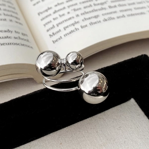 Macro shot of silver sphere ring featuring a spiral design with three polished metal balls