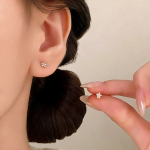 Minimalist star stud earrings with pave zircon, worn by model to show size and scale