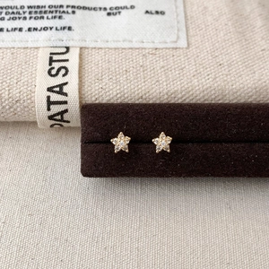 Close-up of elegant gold flower stud earrings with sparkling zircon inlay on display