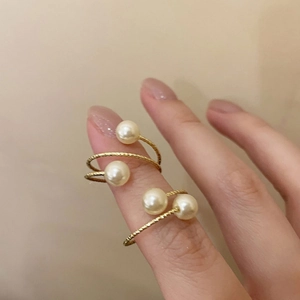 Elegant gold spiral wrap ring with white pearls featuring a textured twist design