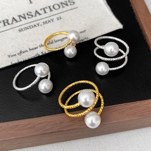 Detail view of 4-piece pearl ring set in gold and silver finish on a vintage background