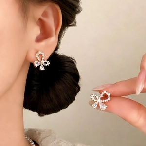 Elegant gold bow earrings with white pearls and teardrop zircon crystals for women