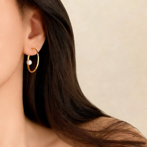 Boucle d'oreille anneau doré minimaliste avec perle blanche portée à l'oreille
