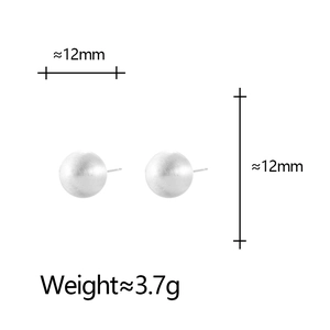 Macro detail of 12mm silver ball stud earrings with matte brushed metal finish