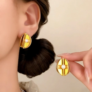 French retro gold-plated oval stud earrings with white pearl detail on model