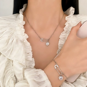 Ensemble collier et bracelet trombone argenté avec zircons coeur sur un mannequin