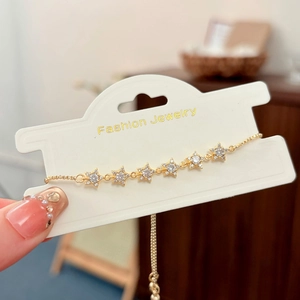Macro view of adjustable gold star bracelet with sparkling cubic zirconia on display card