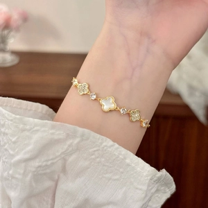 Elegant gold clover bracelet featuring white mother of pearl and shimmering zircons