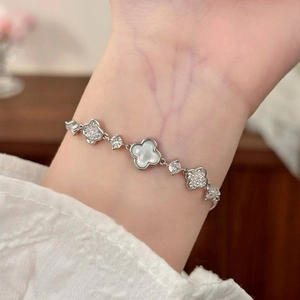 Elegant silver quatrefoil bracelet with white mother-of-pearl and pavé-set zircons on wrist