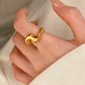 Modern minimalist irregular gold wave ring for women with polished finish on model