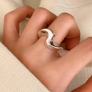 Minimalist silver wavy ring with polished finish worn on finger for a stylish look