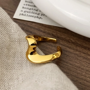 Macro detail of gold wavy open ring with high-polished irregular streamline design