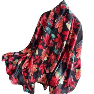 Elegant long silk scarf with red maple leaves and green accents on a black background