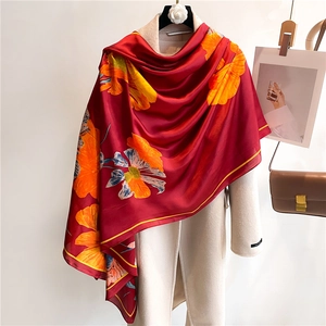 Vue détaillée d'une écharpe en soie de luxe à motif de lys drapée sur un manteau