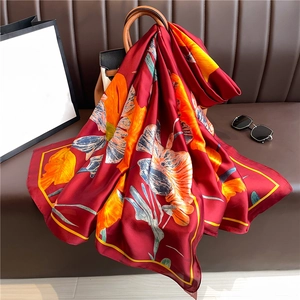 Grand foulard de luxe en soie à imprimé fleuri drapé sur un sac à main en cuir chic