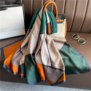 Detailed close-up of a luxury color-block silk scarf with classic houndstooth pattern