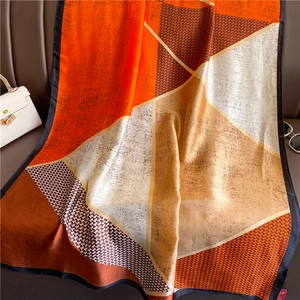 Luxurious geometric color block silk scarf with houndstooth pattern on leather background