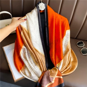 Macro detail of luxury silk scarf showing geometric color blocks and houndstooth pattern
