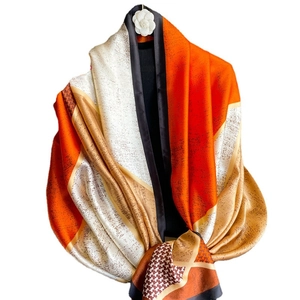 Luxury color-block silk shawl featuring orange geometric patterns and houndstooth texture