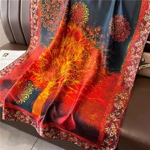 Luxurious red silk scarf with golden tree of life pattern on dark leather background