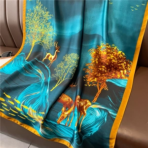Close-up of luxury floral silk shawl showing golden deer and oriental forest patterns
