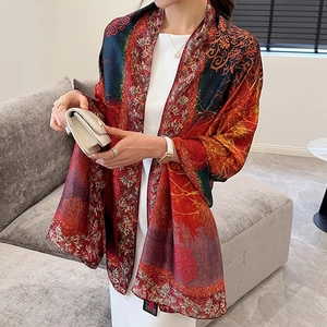 Luxury floral silk scarf in vibrant red and gold styled as an elegant long shawl wrap