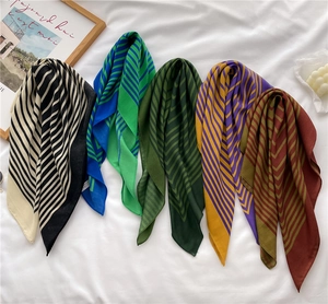 Close-up of vibrant striped silk-like scarves in varied geometric color patterns