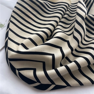 Detail of soft herringbone stripe scarf showing fine woven texture and premium fabric drape