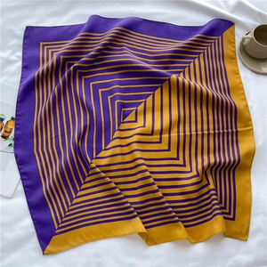 Detailed texture of purple and yellow geometric silk scarf on white fabric background